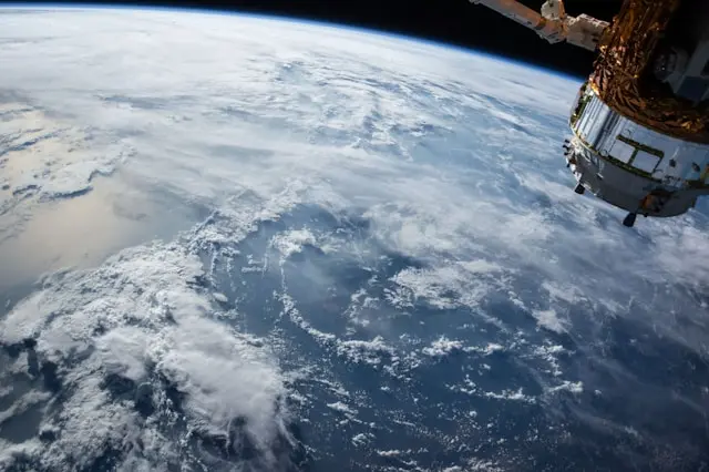 Blick auf die Erde aus dem Weltall mit Satellit im Vordergrund