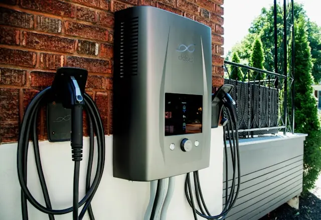 Ladestation für Elektroautos mit zwei Ladekabeln an einer Backsteinwand als Bezug zum Kursrückgang der Vicor Aktie