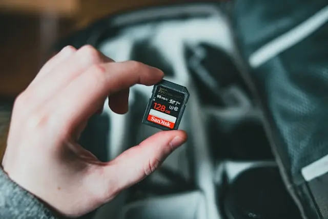 Hand hält eine SanDisk-SD-Karte mit 128 GB als Bezug zur Kursgeschichte des Speicherchipherstellers und seinem Weg vom Spinoff zum Highflyer