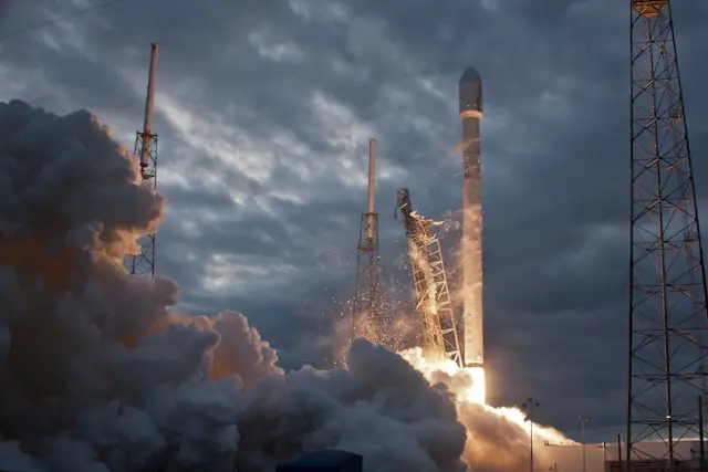 SpaceX Falcon-Rakete beim Abheben von der Startrampe inmitten dichter Rauch- und Flammenwolken als Bezug zum geplanten Börsengang und der KI-Wachstumsstrategie des Raumfahrtkonzerns