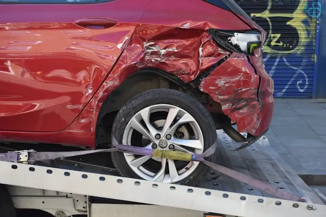 Stark beschädigtes rotes Auto auf einem Abschleppwagen als Bezug zum Kerngeschäft von Boyd Group, dem größten Karosserie- und Unfallreparaturanbieter Nordamerikas