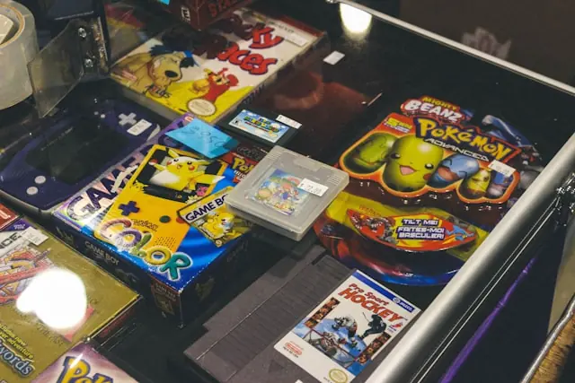 Loses Modul und verpackte Spiele in der Vitrine eines Retro-Händlers Loses Game-Boy-Modul zwischen originalverpackten Spielen und einer Konsole in einer Verkaufsvitrine als Bezug zum Preisabstand bei Komplettware