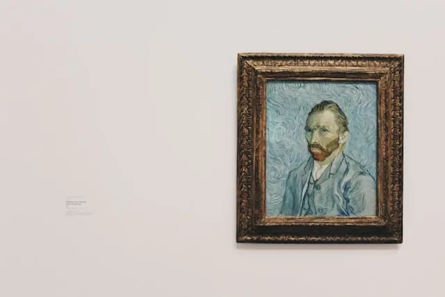Provenienzlücken am Kunstmarkt mit gerahmtem Gemälde und Wandschild Gerahmtes Ölporträt im Goldrahmen an heller Museumswand neben einem Beschriftungsschild im Zusammenhang mit Provenienzlücken bei Kunstwerken