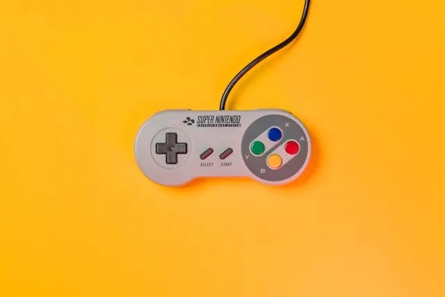 Retro-Spielecontroller auf gelbem Hintergrund Retro-Spielecontroller auf gelbem Hintergrund