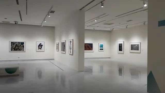 Galerie mit gerahmten Kunstwerken an weißen Wänden Galerie mit gerahmten Kunstwerken an weißen Wänden