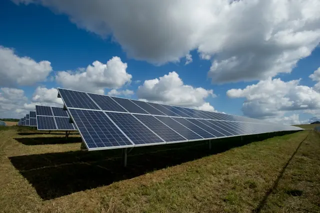Solarpacht mit dem Zehnfachen an Ertrag bei Freiflächenanlage Aufgeständerte Solarmodule in langen Reihen auf einer Grünfläche als Bezug zur Solarpacht mit langer Vertragsbindung