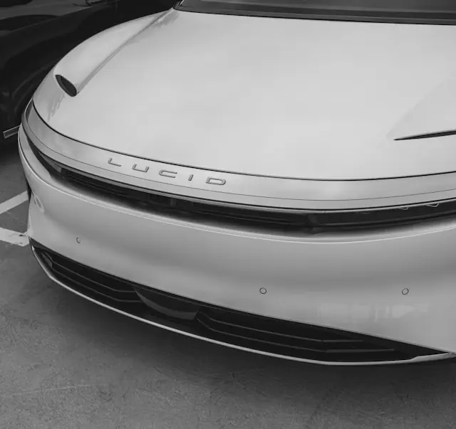 Lucid dementiert Insolvenzgerüchte – Fahrzeugfront mit Schriftzug Front eines hellen Lucid-Elektroautos mit Markenschriftzug in Schwarz-Weiß als Bezug zum Kurssprung nach dementierten Insolvenzgerüchten