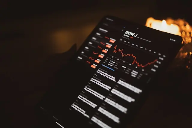 Großer Verfallstag an der Börse – Dow-Jones-Kurse auf dem Tablet Hand hält ein Tablet mit dem Dow-Jones-Index, einem Linienchart und roten Kursdaten als Bezug zum großen Verfallstag