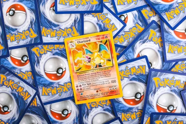 Pokémon-Karte im Wert von 16,5 Millionen mit Charizard auf Kartenstapel Pokémon-Sammelkarte mit Charizard auf einem Stapel von Kartenrückseiten als Bezug zum Verkaufspreis von 16,5 Millionen