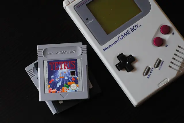 Grading von Retro-Spielen mit Game Boy und Tetris-Modul Nintendo Game Boy neben gestapelten Spielmodulen mit Tetris obenauf vor dem Hintergrund der Bewertung durch Grading-Dienste