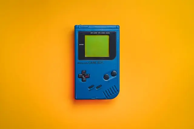 Game Boy in Blau, warum der Karton den Preis von Retro-Konsolen bestimmt Blauer Nintendo Game Boy auf gelbem Hintergrund als Bezug zum Einfluss der Originalverpackung auf den Preis von Retro-Konsolen