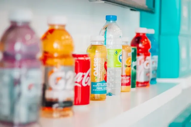 National-Beverage-Sonderdividende – Getränkeflaschen im Kühlregal Verschiedene Getränkeflaschen und -dosen unterschiedlicher Marken auf einem Regal als Bezug zur Getränkebranche rund um die Sonderdividende