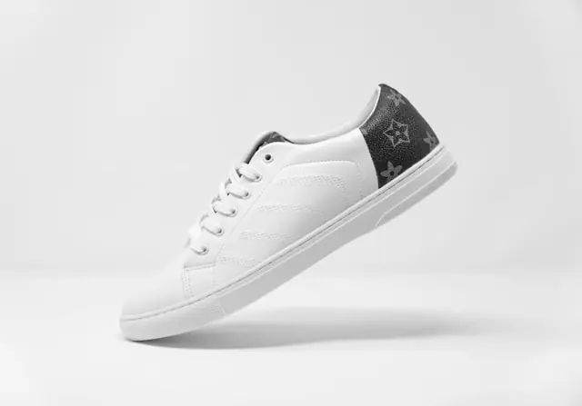 Sneaker-Markt zwischen Kursgewinn und Hype-Flip mit weißem Ledersneaker Weißer Ledersneaker mit dunklem Fersenbesatz und Monogramm-Muster freigestellt vor hellem Hintergrund im Zusammenhang mit der Entwicklung am Sneaker-Markt