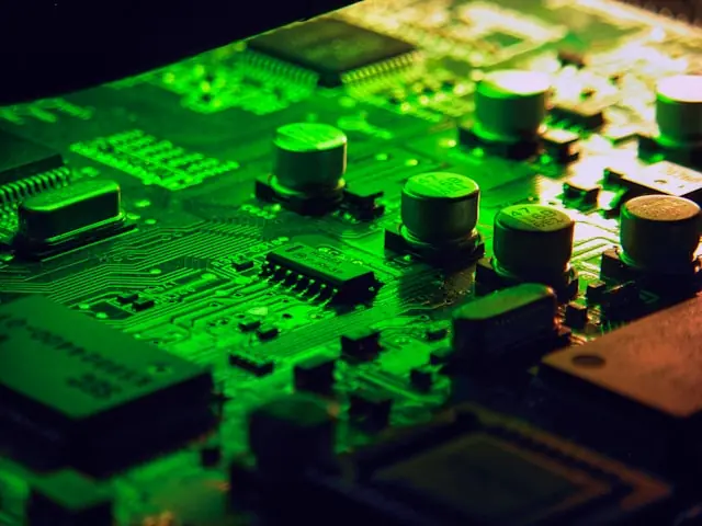 Aehr Test Systems mit Insiderverkäufen und Nahaufnahme einer Platine Grün beleuchtete Platine mit Kondensatoren und Chips in Nahaufnahme als Bezug zu den Insiderverkäufen bei Aehr Test Systems